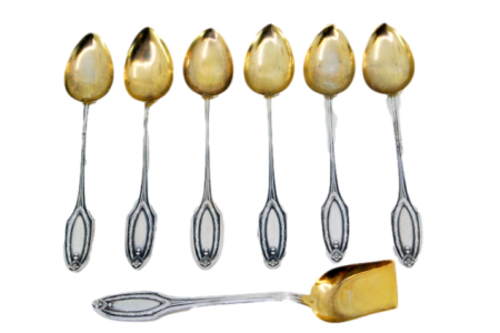 Conjunto de seis colheres de café e pá de açúcar em prata com relevos nos cabos e nas conchas douradas.